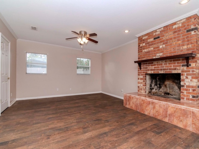 unfurnished living room featuring ceiling fan, dark hardwood / wood-style flooring, crown molding, and a brick fireplace