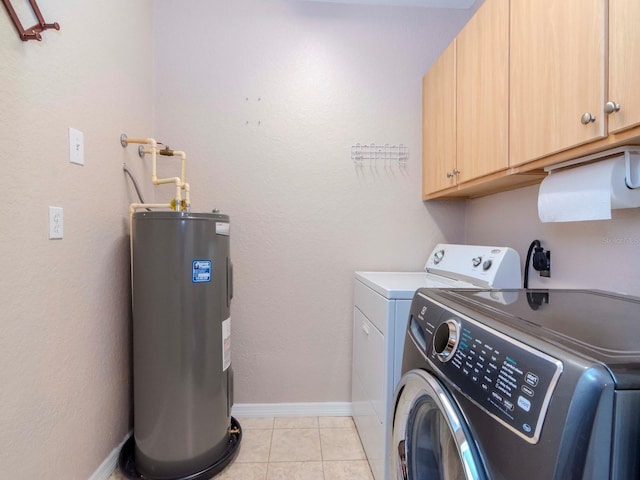 laundry area featuring cabinets, electric water heater, light tile patterned floors, and separate washer and dryer