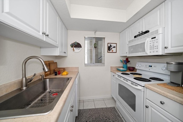 kitchen featuring light tile patterned flooring, white appliances, white cabinetry, and sink