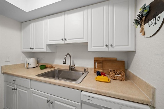 kitchen with dishwasher, sink, and white cabinets