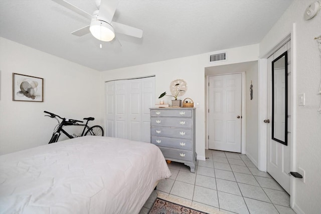 bedroom featuring ceiling fan, a closet, and light tile patterned floors