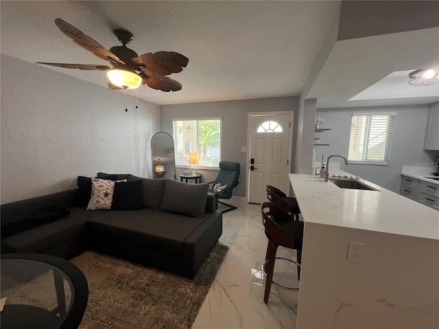 2704 2nd St Unit 7, Indian Rocks Beach, FL 33785 - living area featuring light marble finish flooring, a ceiling fan, and a textured wall