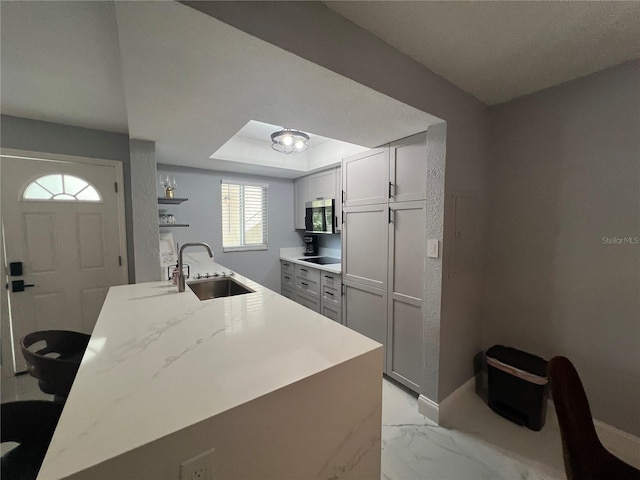 2704 2nd St Unit 7, Indian Rocks Beach, FL 33785 - kitchen featuring light marble finish flooring, stainless steel microwave, black electric cooktop, open shelves, and light stone countertops