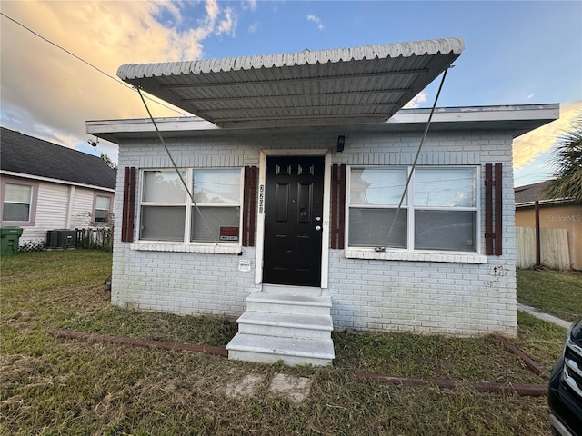 exterior space featuring central AC unit and a yard