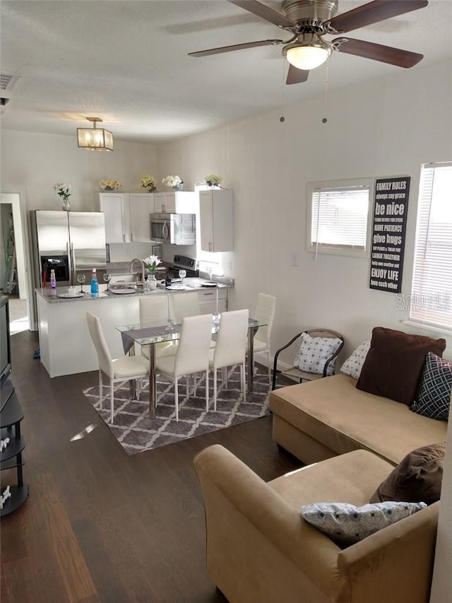 living room featuring dark hardwood / wood-style flooring and ceiling fan