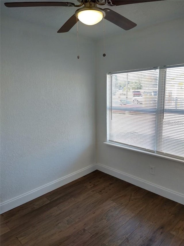 spare room featuring dark hardwood / wood-style flooring and ceiling fan