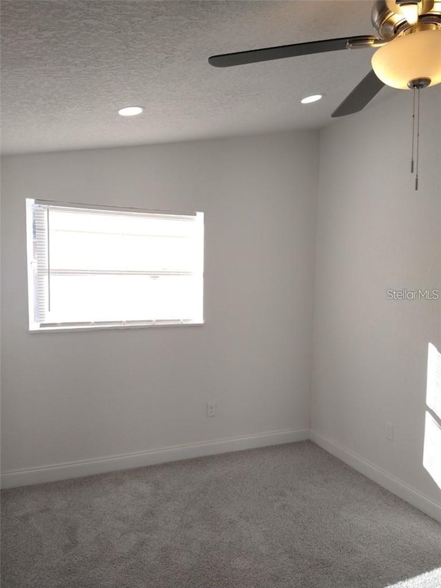 carpeted empty room featuring ceiling fan, a textured ceiling, and lofted ceiling