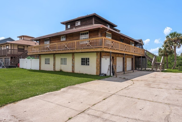 rear view of house featuring a lawn and a garage