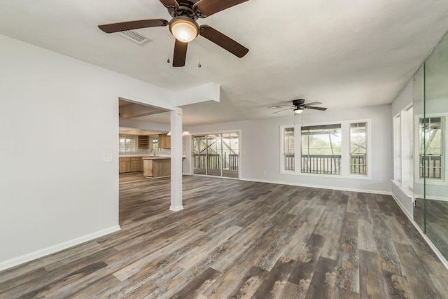 unfurnished living room featuring ceiling fan and dark hardwood / wood-style floors