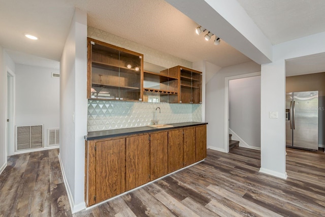 kitchen featuring sink, backsplash, dark hardwood / wood-style floors, and stainless steel fridge