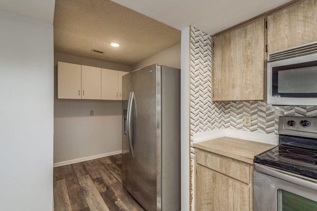 kitchen with cream cabinetry, decorative backsplash, stainless steel appliances, a textured ceiling, and dark hardwood / wood-style floors