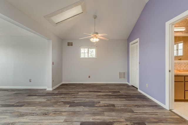 empty room featuring lofted ceiling, ceiling fan, and dark hardwood / wood-style flooring