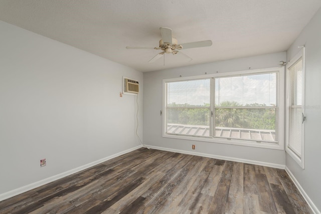 spare room featuring a wealth of natural light, ceiling fan, dark wood-type flooring, and a wall mounted AC