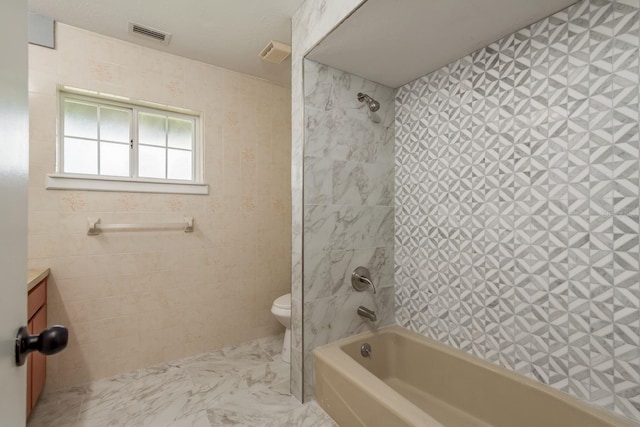 full bathroom with vanity, tiled shower / bath combo, and toilet