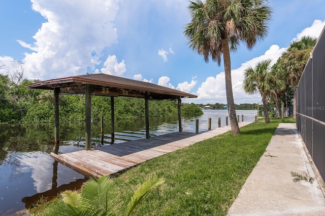 view of dock featuring a water view and a yard