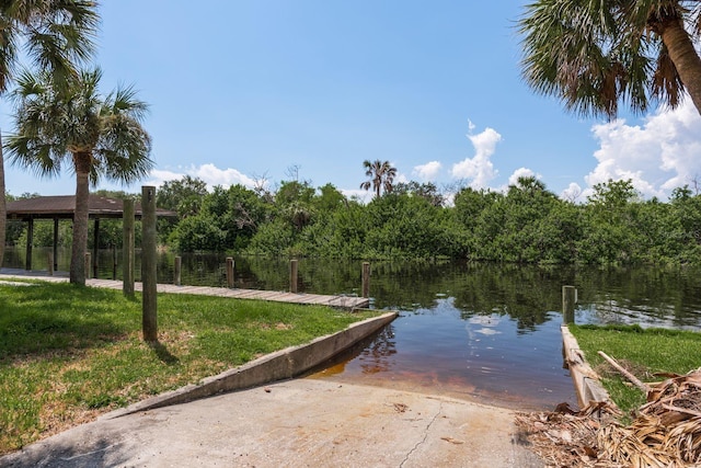 view of dock featuring a lawn and a water view