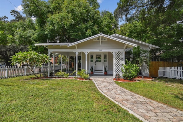 bungalow-style home with covered porch and a front yard