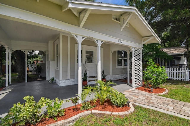 entrance to property with covered porch and a carport