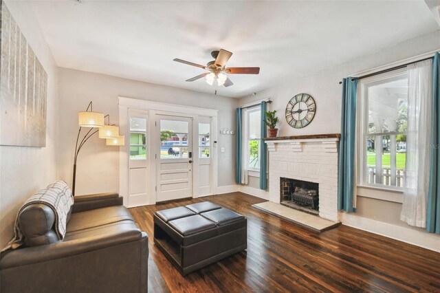 living room featuring a brick fireplace, a wealth of natural light, ceiling fan, and dark hardwood / wood-style floors