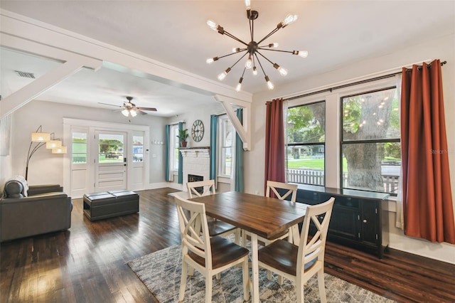 dining room featuring ceiling fan with notable chandelier, dark wood-type flooring, and a healthy amount of sunlight