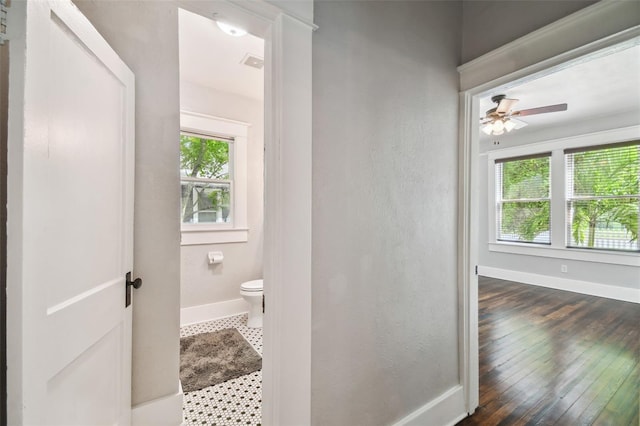 bathroom featuring ceiling fan, hardwood / wood-style flooring, toilet, and a wealth of natural light