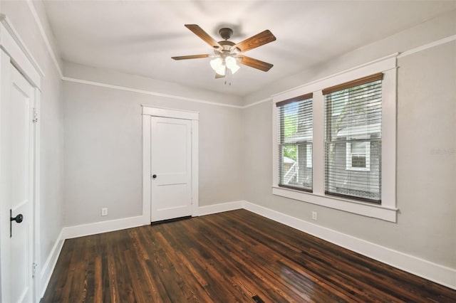 empty room with dark hardwood / wood-style flooring and ceiling fan