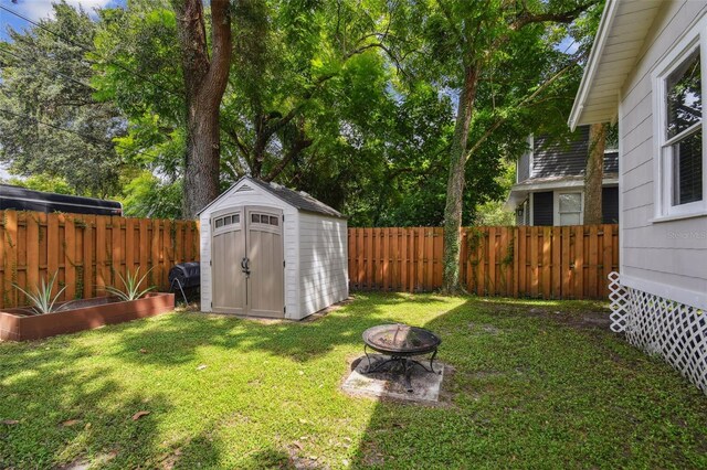 view of yard with a shed and a fire pit