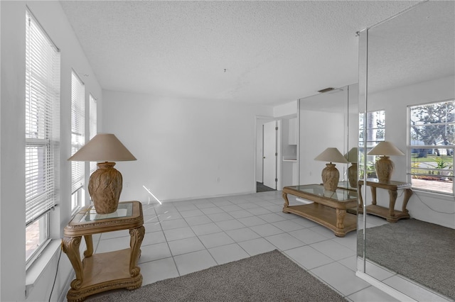 interior space with light tile patterned flooring and a textured ceiling