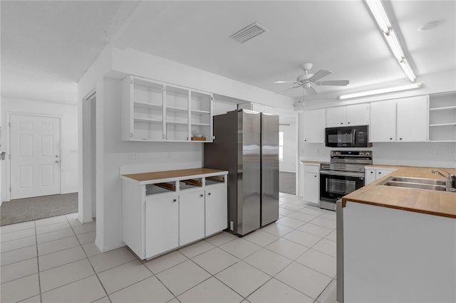 kitchen with white cabinetry, appliances with stainless steel finishes, sink, and light tile patterned flooring