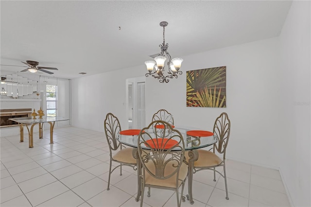 tiled dining space featuring ceiling fan with notable chandelier