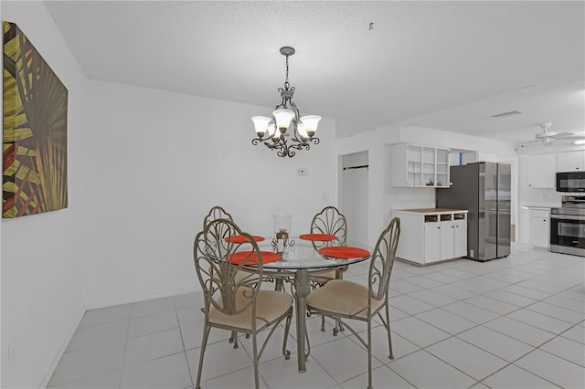 dining room featuring light tile patterned flooring, ceiling fan with notable chandelier, and a textured ceiling