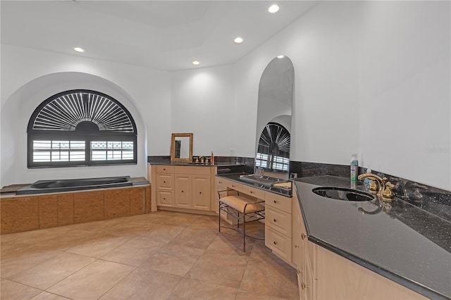 bathroom with sink, tiled tub, a raised ceiling, and tile patterned floors