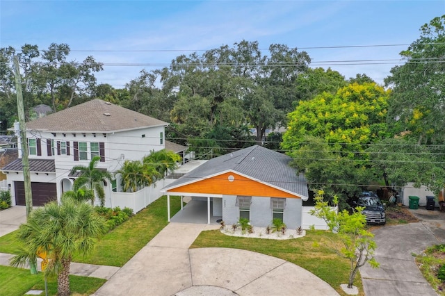 view of front of property featuring a front lawn, driveway, and fence