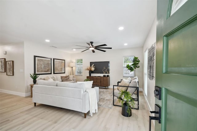 living room featuring visible vents, baseboards, ceiling fan, recessed lighting, and light wood-style flooring