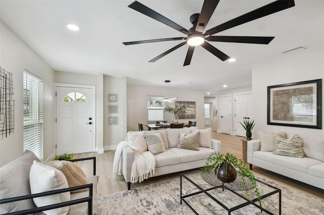 living area featuring recessed lighting, visible vents, light wood finished floors, and baseboards