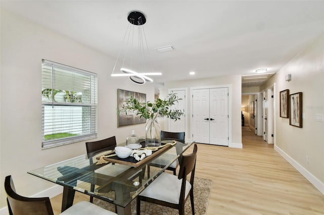 dining space featuring baseboards and light wood finished floors