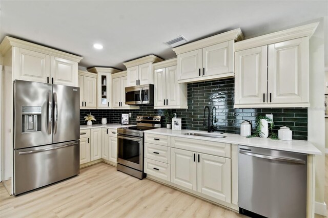 kitchen featuring visible vents, a sink, light countertops, appliances with stainless steel finishes, and backsplash