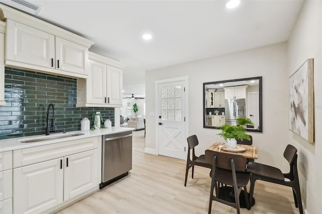 kitchen featuring visible vents, light wood-style flooring, a sink, appliances with stainless steel finishes, and light countertops