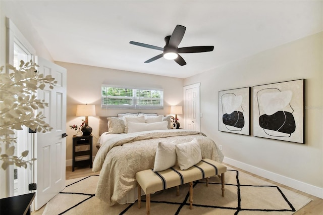 bedroom with ceiling fan, baseboards, a closet, and light wood-type flooring