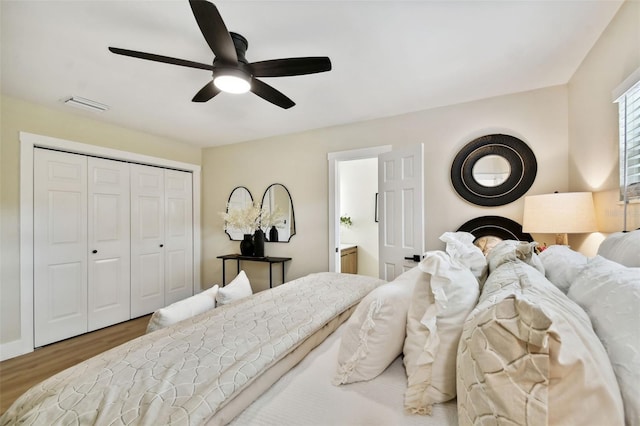 bedroom featuring a closet, visible vents, a ceiling fan, and wood finished floors