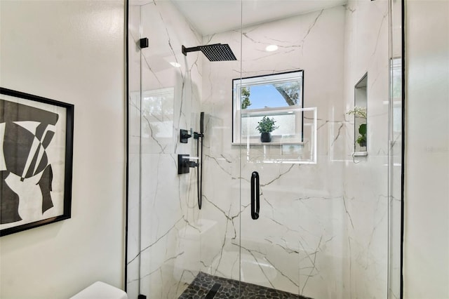 full bath with a marble finish shower and toilet