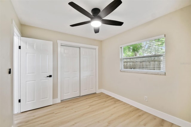 unfurnished bedroom featuring a closet, light wood-style flooring, a ceiling fan, and baseboards