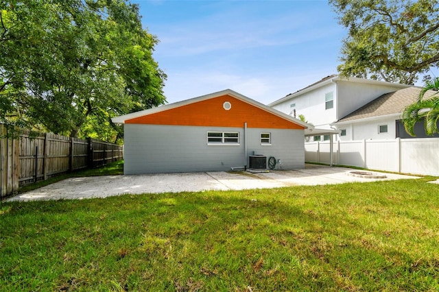 rear view of house featuring a lawn, central AC, a fenced backyard, and a patio area