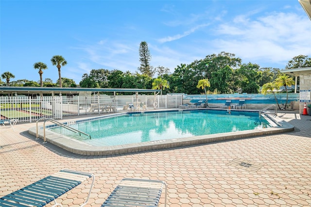 pool featuring fence and a patio area