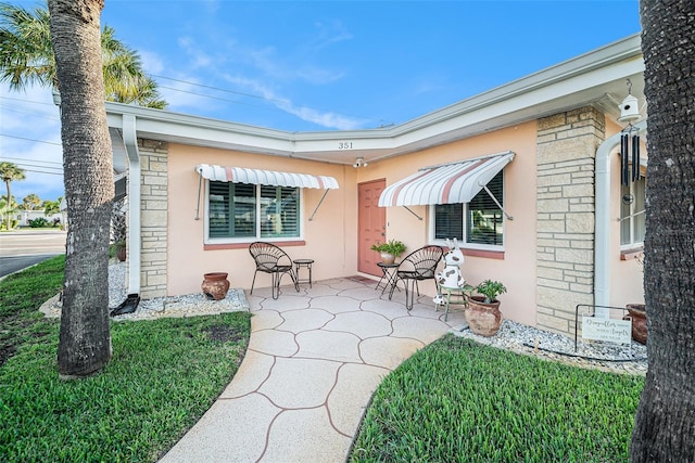 back of property featuring a patio and stucco siding