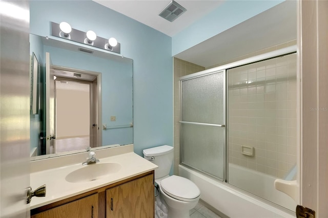 full bathroom featuring shower / bath combination with glass door, vanity, tile patterned flooring, and toilet