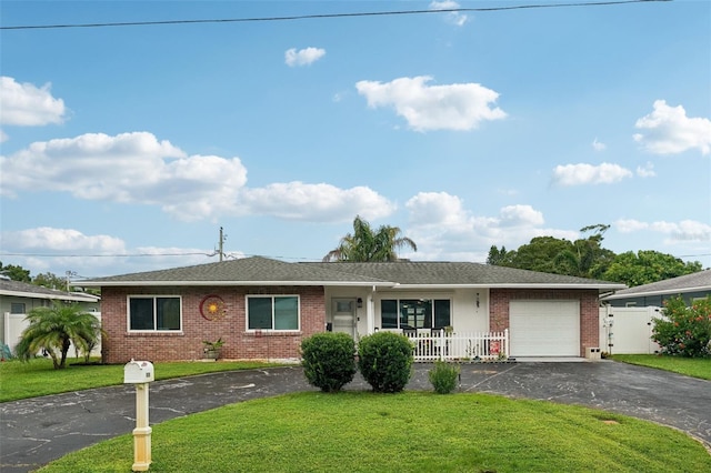 ranch-style house featuring a front yard, a garage, and covered porch