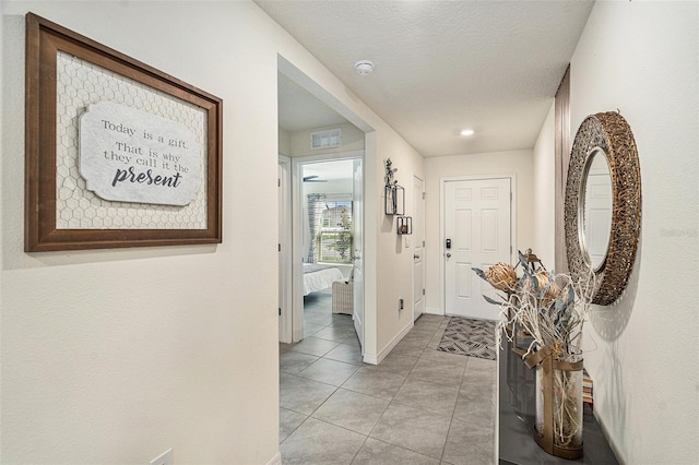 tiled entrance foyer featuring a textured ceiling