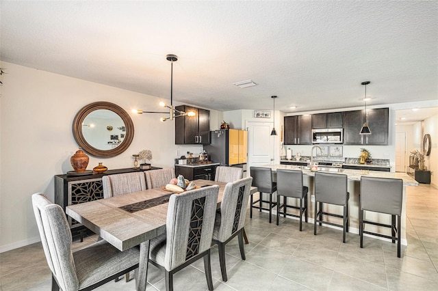 dining room featuring an inviting chandelier, light tile patterned floors, and a textured ceiling