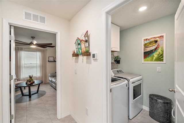 laundry area with ceiling fan, light tile patterned floors, a textured ceiling, cabinets, and independent washer and dryer